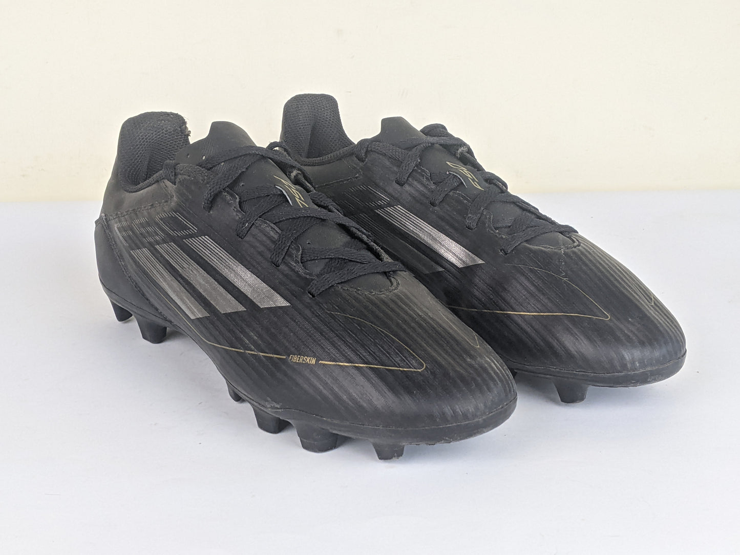 adidas F50 Club FxG Dark Spark - Core Black/Iron Metal/Gold Metallic