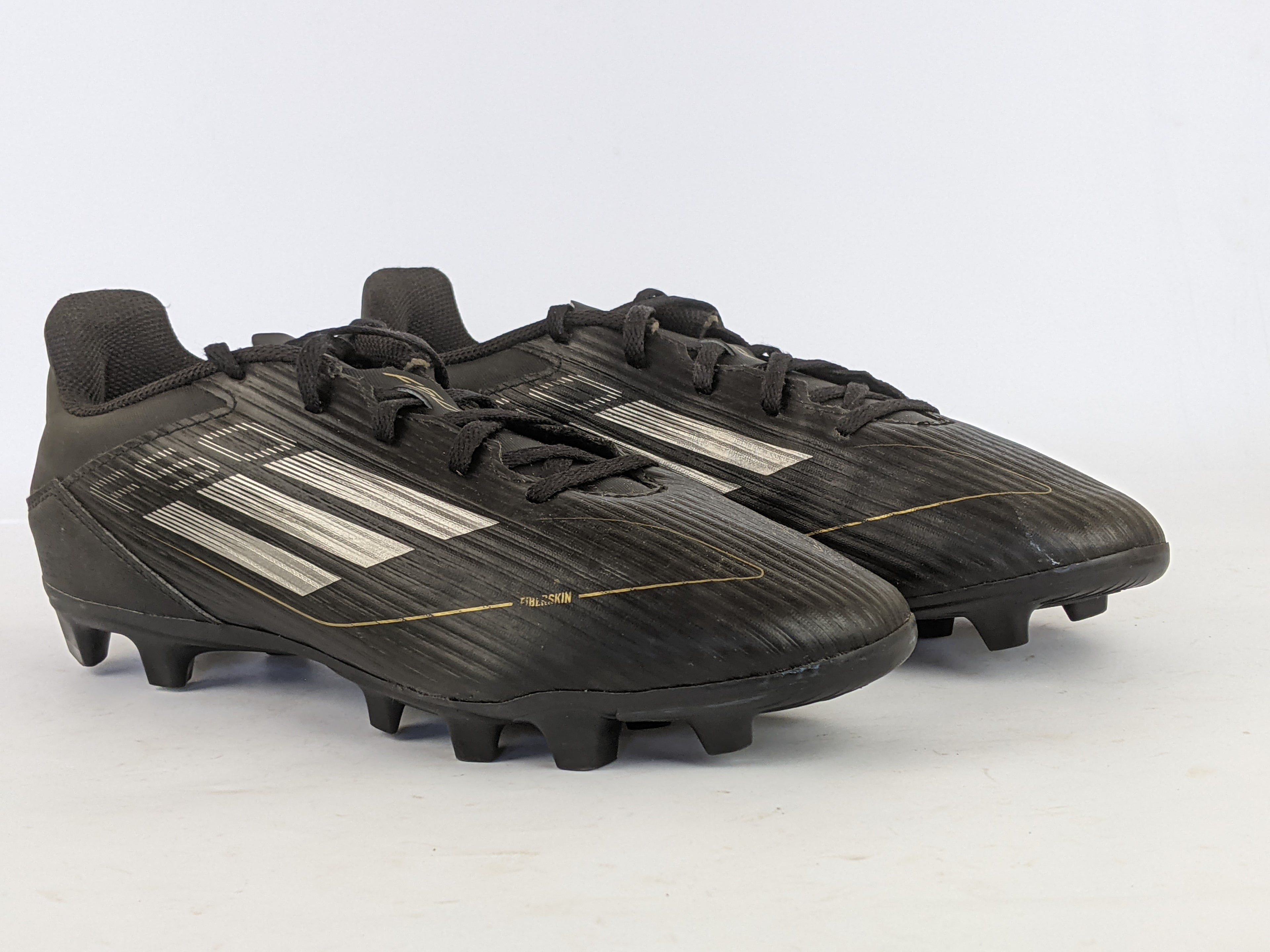adidas F50 Club FxG Dark Spark - Core Black/Iron Metal/Gold Metallic