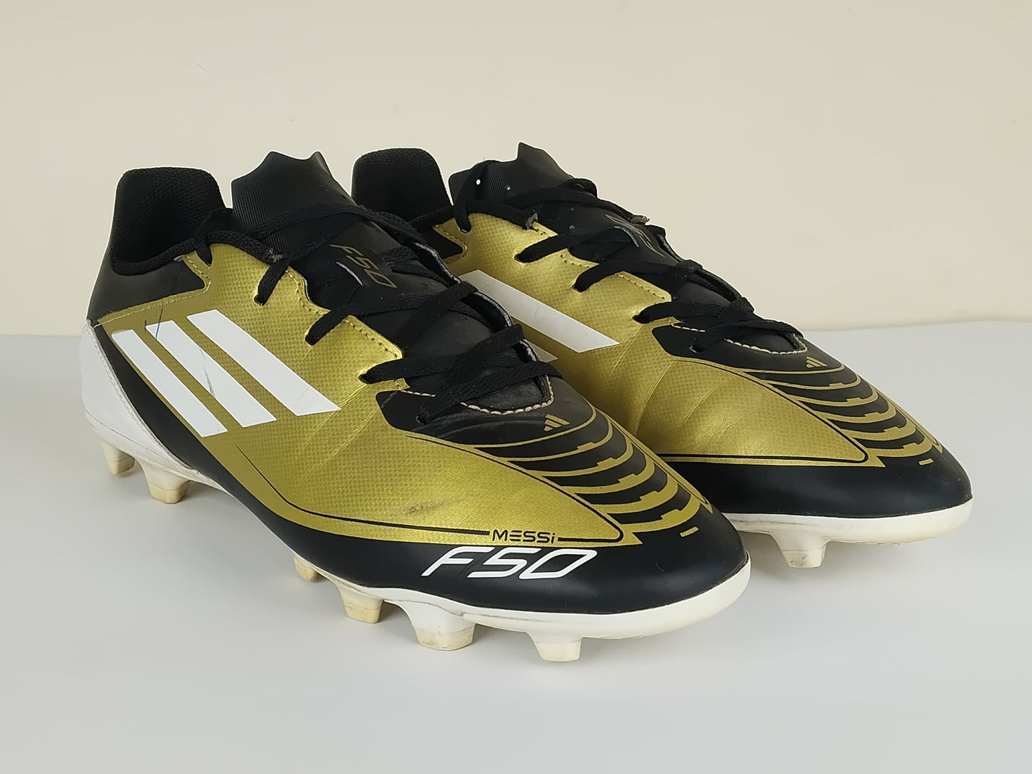 adidas F50 Messi Club FxG Triunfo Dorado - Gold Metallic/Footwear White/Core Black