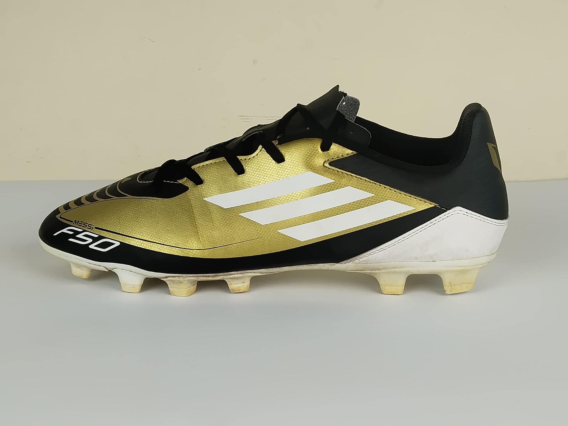 adidas F50 Messi Club FxG Triunfo Dorado - Gold Metallic/Footwear White/Core Black