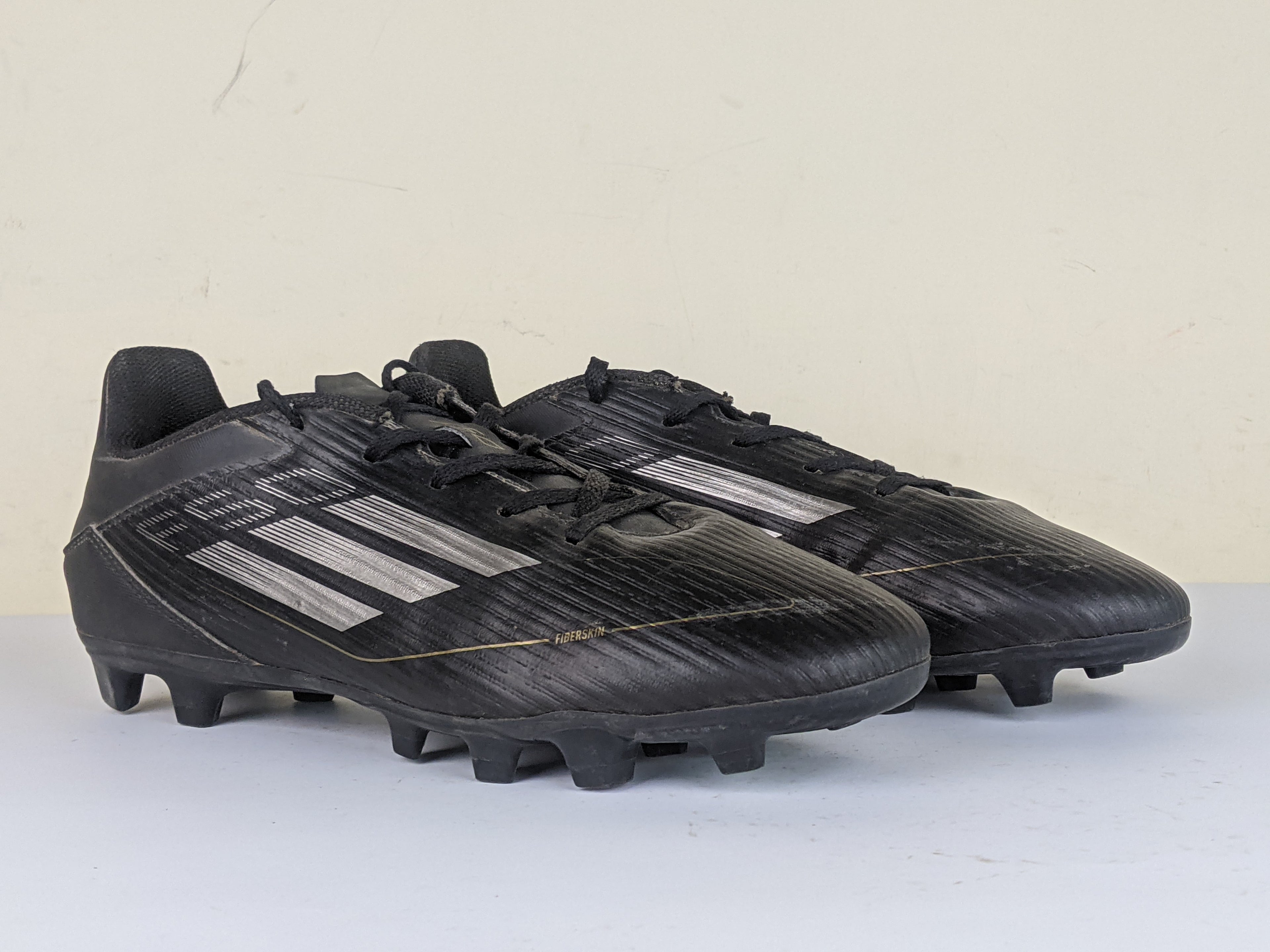 adidas F50 Club FxG Dark Spark - Core Black/Iron Metal/Gold Metallic
