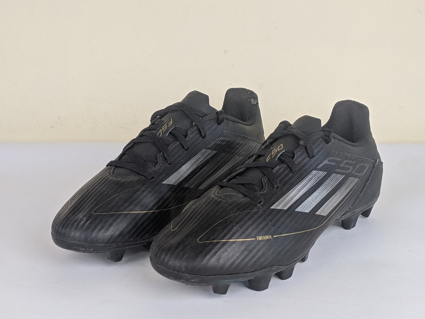 adidas F50 Club FxG Dark Spark - Core Black/Iron Metal/Gold Metallic
